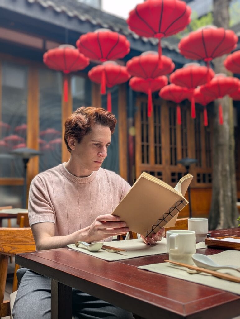 Scoot reads a menu at the Michelin Upper House restaurant in Chengdu