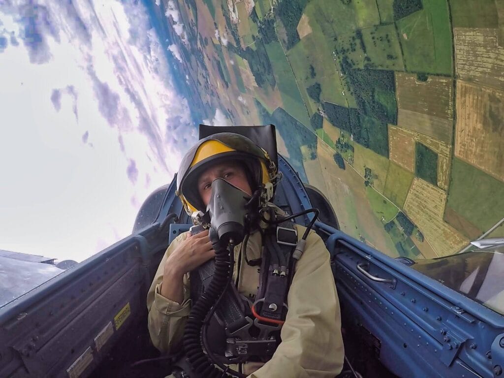 A GoPro shot of Scoot taking the controls during a barrel roll in a fighter jet.