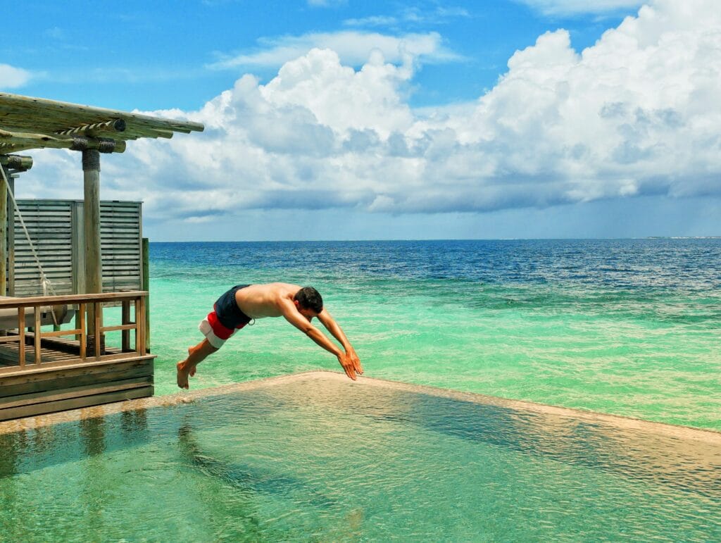 Scoot diving into a private infinity pool in the Maldives.