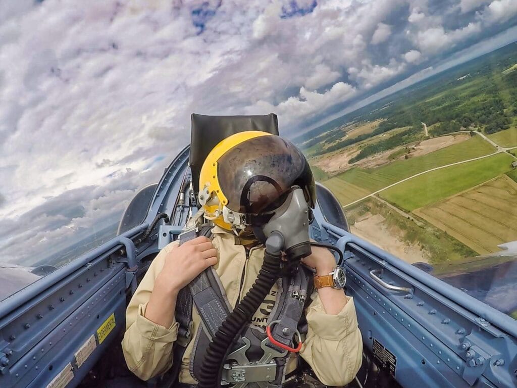 Scoot wearing a flight helmet and oxygen mask during a high-speed L-39 Albatros flight.