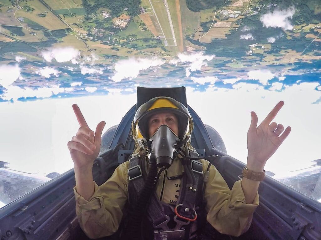 Scoot smiling while flying upside down during a loop as part of his fighter jet experience.