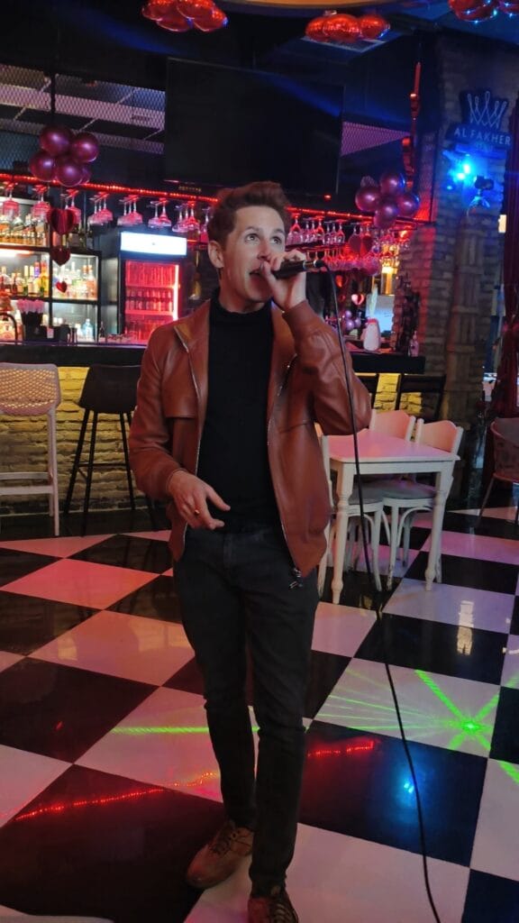 Scoot singing karaoke in a bar during travel to Iraqi Kurdistan