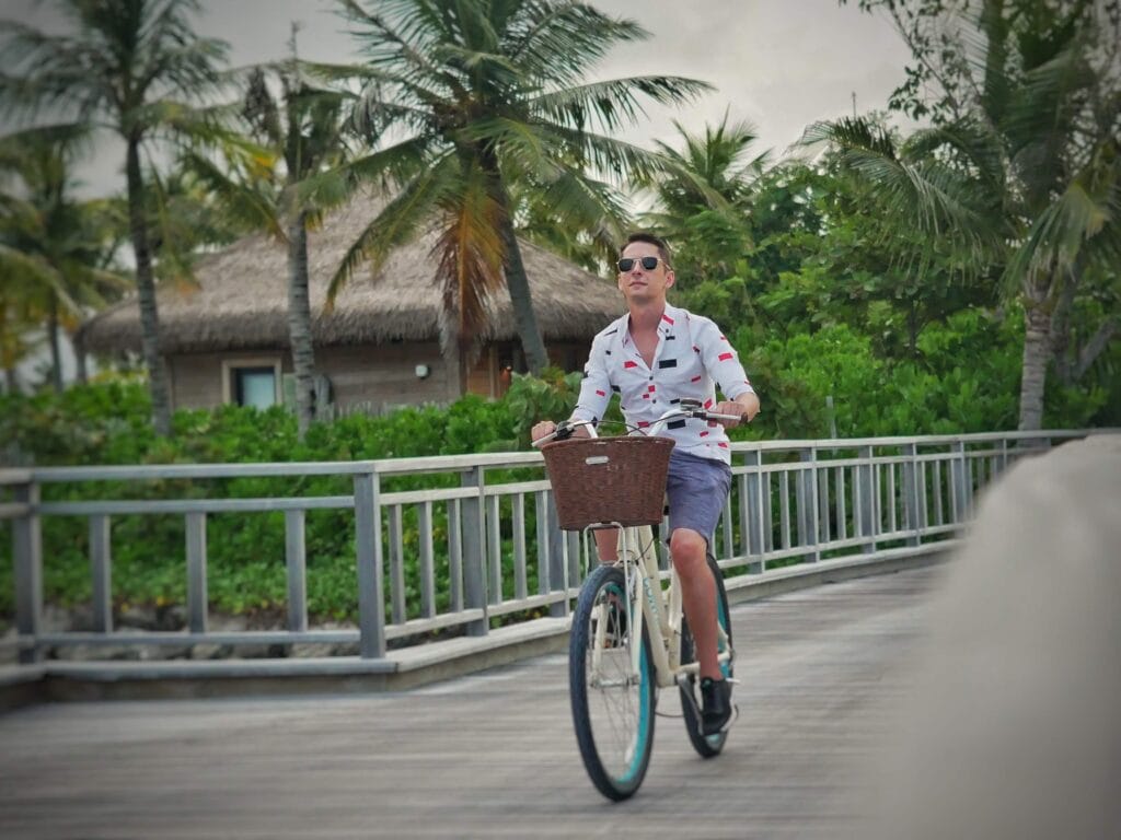 Scoot riding a bike on the jetty at Waldorf Astoria Maldives.