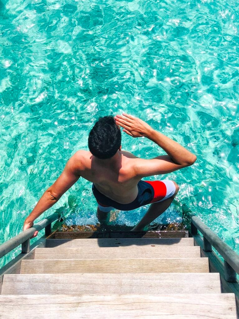 Scoot dipping into the water in the best maldives luxury resort