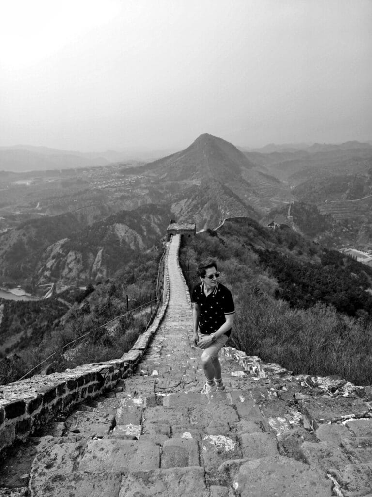 Scoot standing on a sparse great wall simatai in black and white