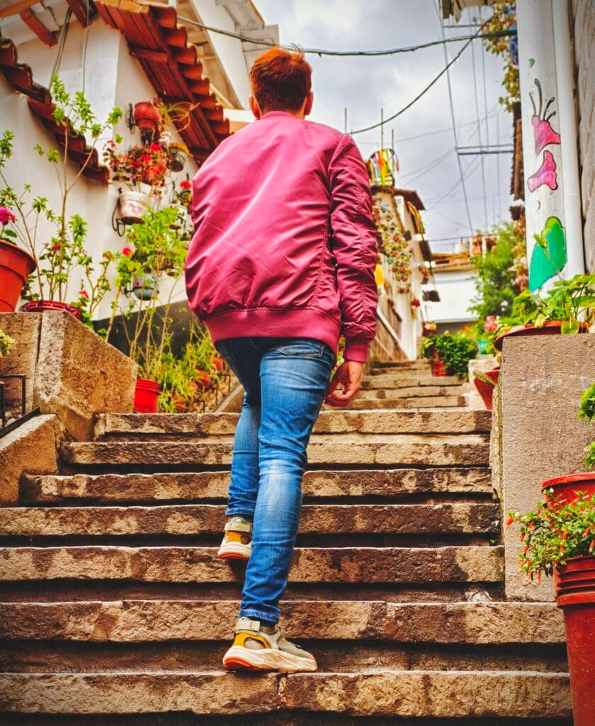 Traveler trying to avoid altitude sickness in cusco on the steep cobblestone uphill streets.