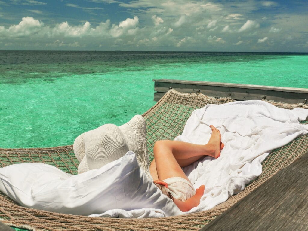 Z lounging in an overwater hammock at Waldorf Astoria Maldives.